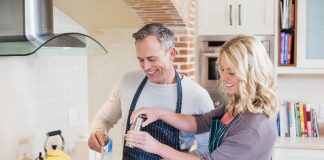 casal cozinhando e pondo em prática o que aprenderam com os chefs de cozinha.