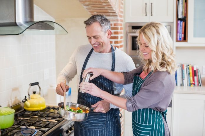 casal cozinhando e pondo em prática o que aprenderam com os chefs de cozinha.