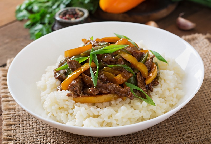 O preço do arroz está alto. Ele é servido com carne e legumes.