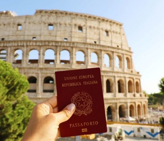 Mulher segura passaporte de cidadania italiana, em frente ao Coliseu.em