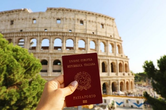 Mulher segura passaporte de cidadania italiana, em frente ao Coliseu.em