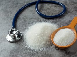 Estetoscópio está ao lado de um punhado de açúcar e chama a atenção ao perigo do diabetes.