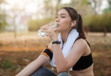 Mulher está sentada no chão, após fazer exercício no parque, porque a atividade física faz parte dos hábitos quem previnem o diabetes