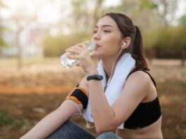 Mulher está sentada no chão, após fazer exercício no parque, porque a atividade física faz parte dos hábitos quem previnem o diabetes