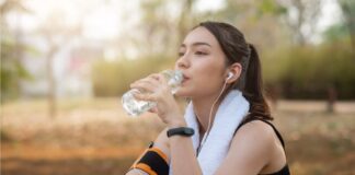 Mulher está sentada no chão, após fazer exercício no parque, porque a atividade física faz parte dos hábitos quem previnem o diabetes