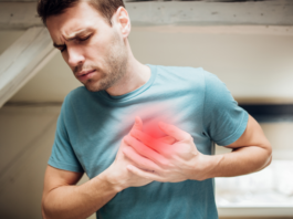 Homem está com as mãos no peito porque o diabetes afeta seu coração e ele está tendo um infarto.