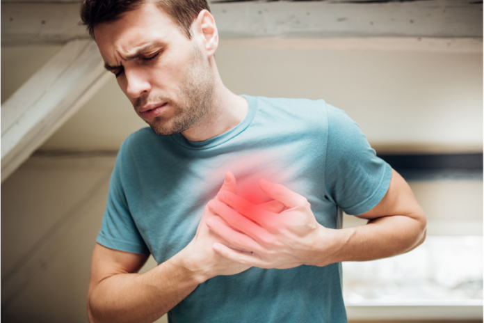 Homem está com as mãos no peito porque o diabetes afeta seu coração e ele está tendo um infarto.